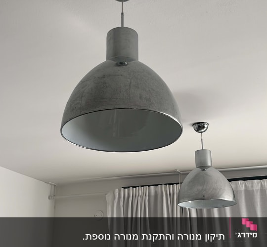 שני מנורות תלויות מהתקרה בחדר עם וילון לבן